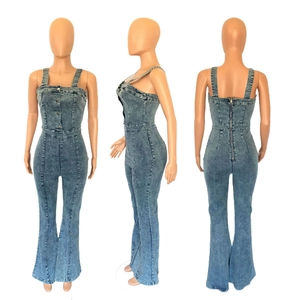 Detail of blue washed denim jumpsuit featuring decorative front buttons and back zipper closure