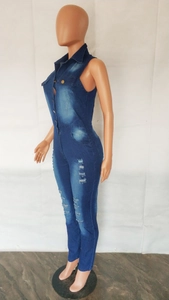 Detail of distressed denim jumpsuit with metal buttons and ripped leg accents
