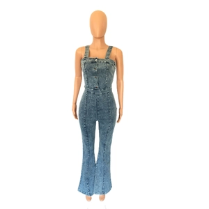 Detail view of light blue denim jumpsuit with metal buttons and flared leg cut on a mannequin