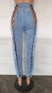 Détail du jean bleu clair taille haute avec laçage latéral et œillets métalliques