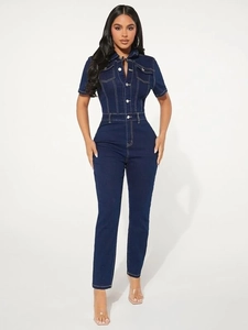 Detail of slim fit dark blue denim jumpsuit with contrast stitching and button pockets