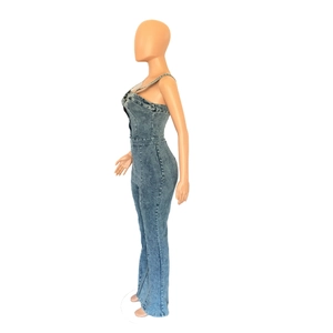 Detail view of denim jumpsuit with spaghetti straps and flared legs on a mannequin