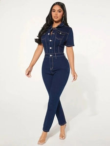 Detail of dark blue denim jumpsuit with metal buttons and chest flap pockets
