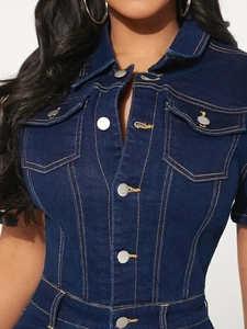Close-up of deep blue denim jumpsuit featuring orange stitching and silver metal buttons