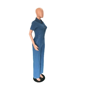 Detail view of denim short sleeve jumpsuit featuring elastic waist and side pockets