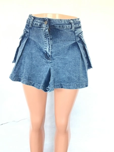 Front detail of high waist washed blue denim skort with utility pockets and metal buttons