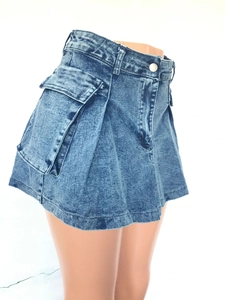 Close-up of a high-waisted denim mini skirt with a large side flap pocket in vintage blue wash
