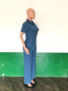 Detail of dark blue denim short sleeve jumpsuit with button-down front and elastic waist