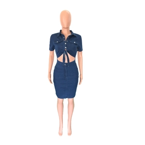 Detail of dark blue denim two-piece set featuring a cropped shirt and high waist skirt