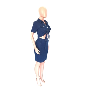 Detail of navy blue two-piece denim set featuring a button-up knotted top and midi skirt