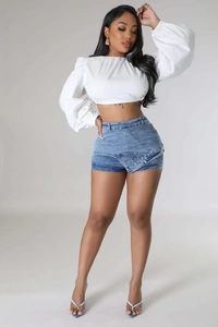 Detail of blue denim shorts with a unique cross-front design and washed texture