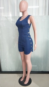 Detail view of dark blue denim romper with gold double-breasted buttons and white stitching