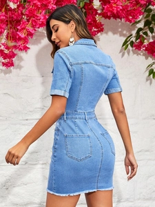Detail of light blue denim mini dress featuring frayed fringe hem and back pockets