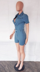 Detail of dark blue denim romper featuring silver metal buttons and side slit hem