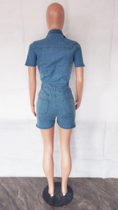 Detail view of denim short romper featuring back pockets and slimming waist seam design