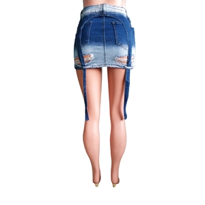 Détail de la jupe en jean avec de longues lanières décoratives et un ourlet déchiré