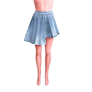Dettaglio gonna a pieghe in denim azzurro con orlo asimmetrico su espositore