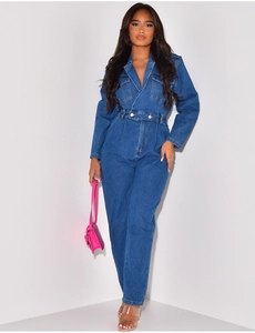 Detail of dark blue denim jumpsuit featuring double gold waist buttons and flap chest pockets