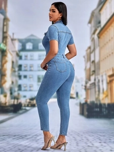 Close-up of light blue slim-fit denim jumpsuit with short sleeves and utility pockets