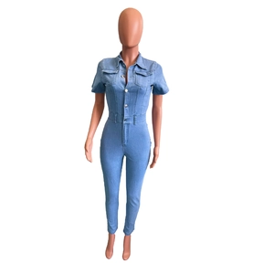 Detail of light blue short-sleeve denim jumpsuit with metal buttons and chest pockets