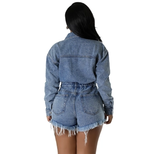 Women's back view of a light blue washed denim romper with fringe hem and elastic waist