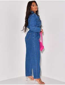 Detailed view of the dark blue denim jumpsuit with long sleeves and pocket accents