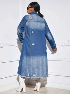 Detailed view of distressed denim coat featuring ripped holes and raw frayed hemline