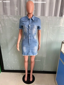 Close-up of light blue denim mini dress featuring raw fringe hem and metal buttons