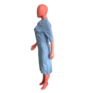 Détail d'une robe midi en denim bleu clair avec fermeture boutonnée et col à revers