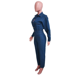 Détail d'une combinaison en jean bleu foncé avec boutons en métal et coupe ajustée