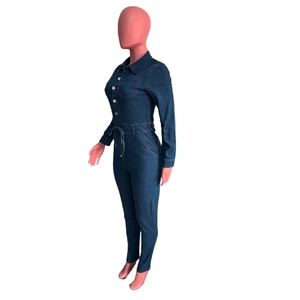 Macro detail of dark blue denim jumpsuit featuring long sleeves and button closure