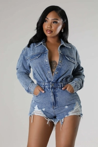 Detail shot of distressed blue wash denim romper with frayed hem and elastic waist