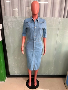 Détail d'une robe midi en jean bleu clair avec boutons métalliques et poches poitrine