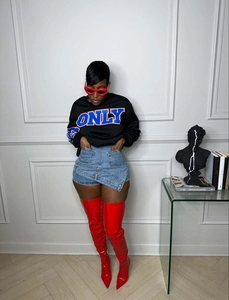 Detailed view of women's casual denim shorts styled with red boots and sunglasses