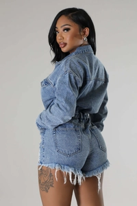 Close-up of high-waist denim shorts featuring stylish distressed frayed hem and fringe details