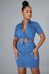 Detailed view of women's two-piece blue denim set with tied waist and buttoned pockets