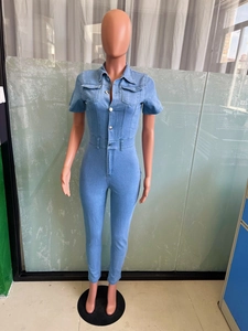Detail view of light blue denim jumpsuit with chest pockets and metal buttons