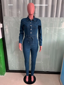Detail of slim fit dark blue denim jumpsuit with front buttons and drawstring waist tie