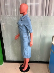 Détail d'une robe midi en jean bleu clair avec boutons en métal et col classique