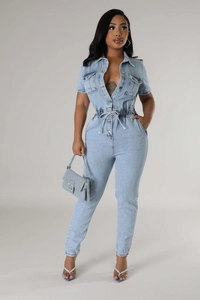 Detail of short sleeve denim jumpsuit with elastic waist and metal buttons in light blue