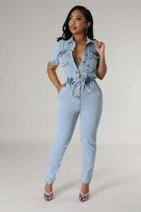 Detail of light blue denim jumpsuit featuring a drawstring waist and chest pockets