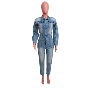 Detail of light blue denim jumpsuit featuring a lapel collar and vintage metal buttons