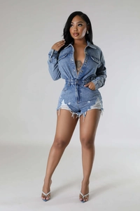 Detail of distressed mid-blue denim romper featuring elastic waist and frayed hem edges