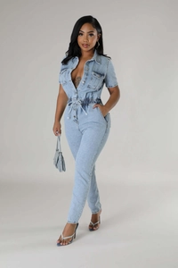Detail of light blue denim jumpsuit featuring a drawstring waist and button-up front