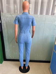 Detail view of the back of a slim fit light blue denim jumpsuit with dual rear pockets