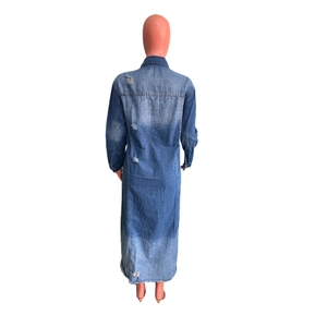 Rear view of long sleeve denim trench coat featuring distressed holes and frayed hem detail