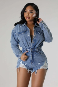 Detailed view of frayed hem and distressed ripped holes on denim short jumpsuit