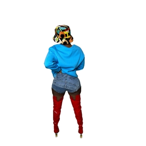 Rear view of casual denim shorts paired with bright red over-the-knee high heel boots