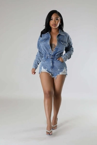 Detail of ripped hem and fringe on high-waist washed denim long sleeve jumpsuit