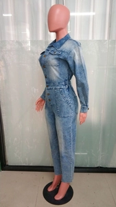 Detail of light blue denim jumpsuit with waist cut, lapels and side pockets on mannequin